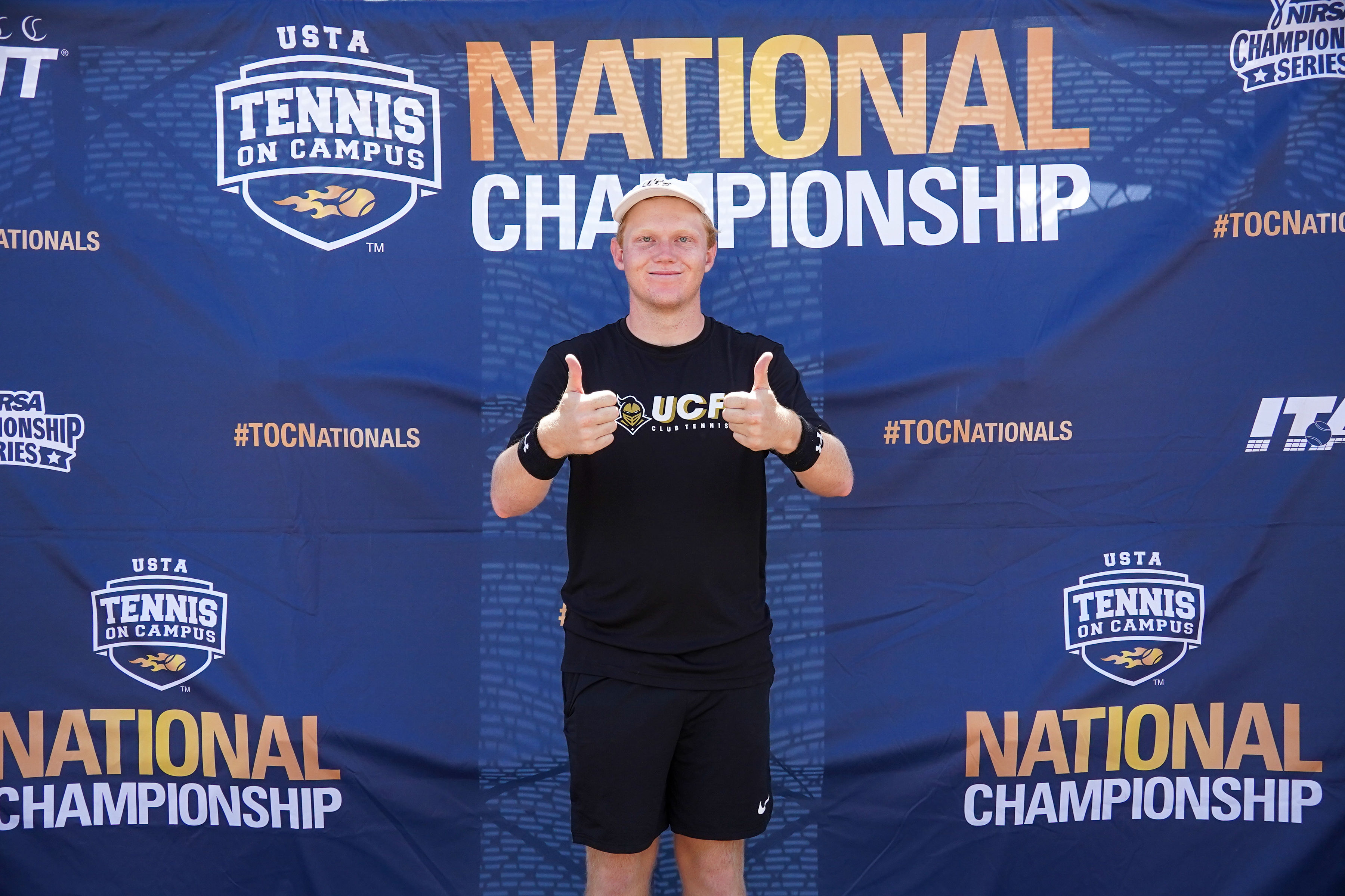 Photo of myself in front of the TOC National Championships banner (2023).